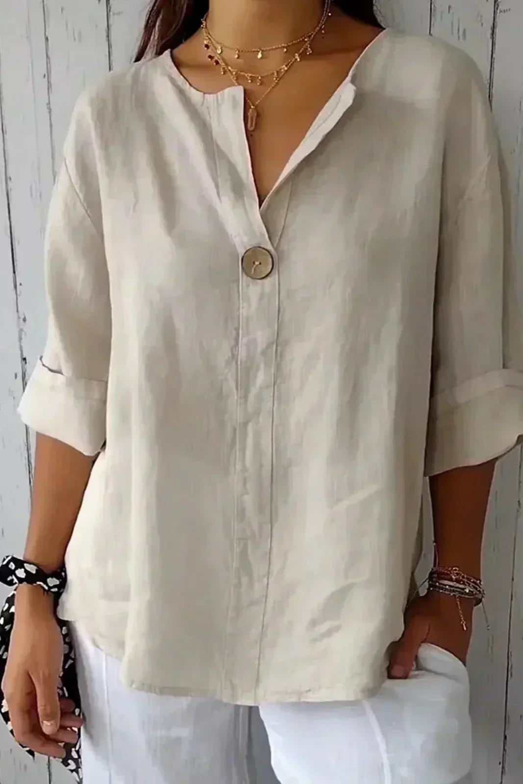 Relaxed off-white button-up top with V-neck and short sleeves, front button placket.