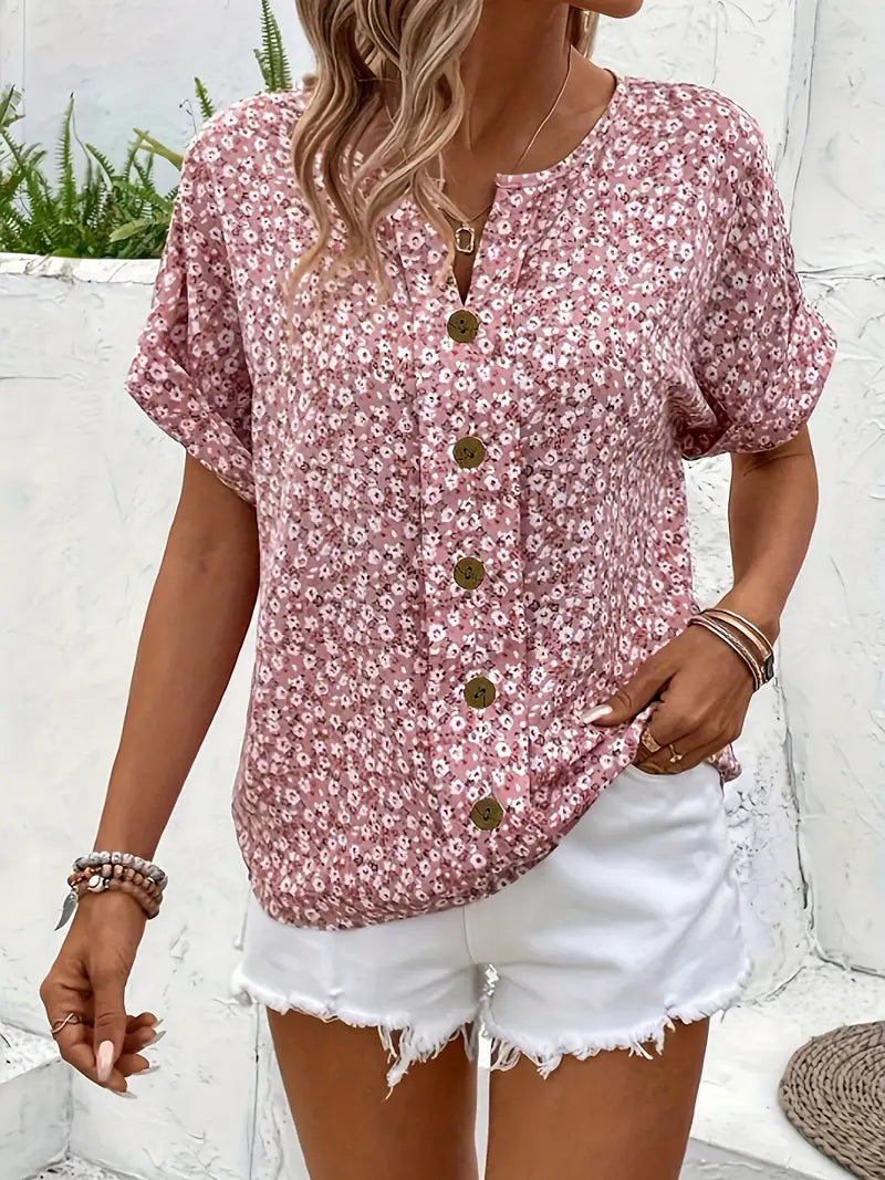 Pink floral print blouse with V-neckline, gold button placket, and short sleeves
