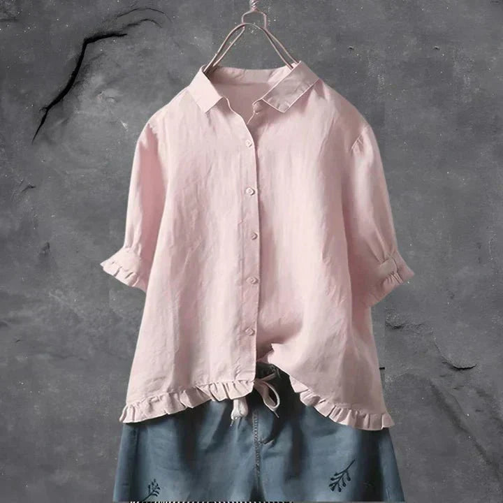 Light pink button-up blouse top with collar, short sleeves, and ruffled hem detail