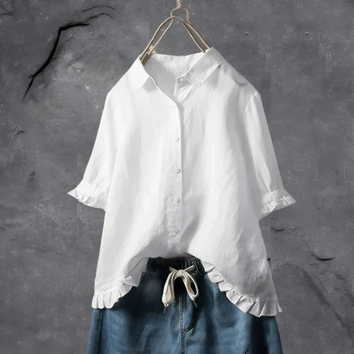 White button-up blouse top with collar, short sleeves, and ruffled hem detail
