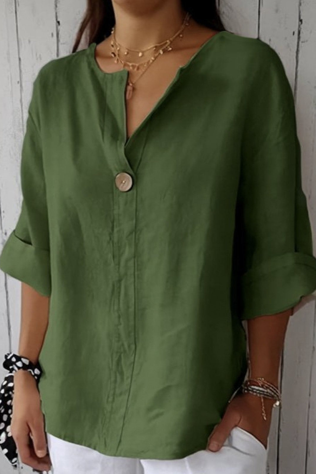 Relaxed green button-up top with V-neck and short sleeves, front button placket.