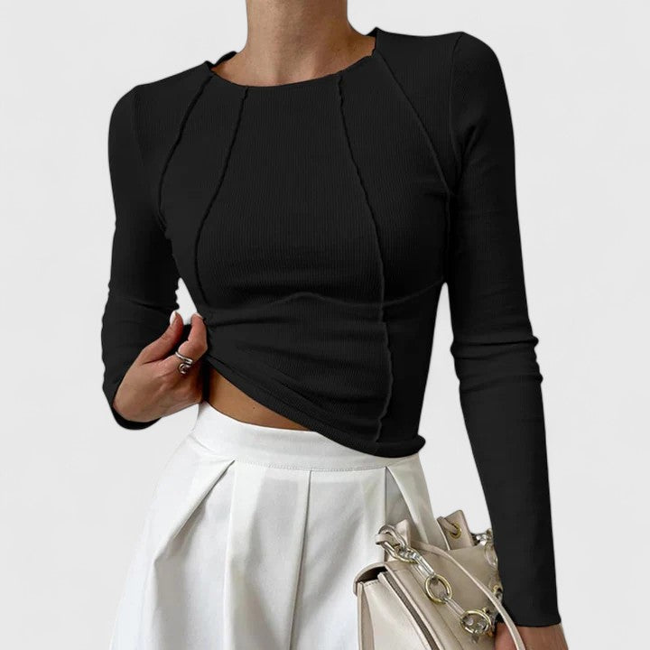 Black long-sleeve knit top with cropped asymmetric hem and twisted front seams.
