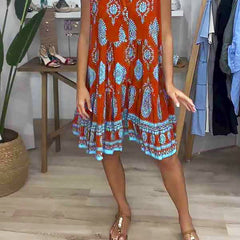Orange V-neck sleeveless dress with blue-and-white ornate print and flared hem