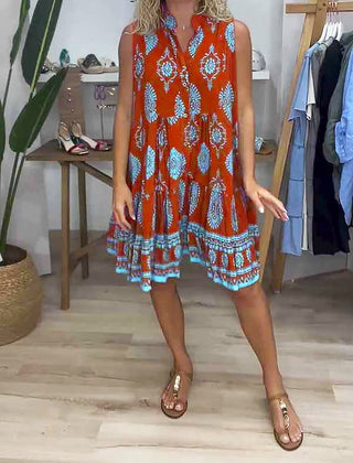 Orange V-neck sleeveless dress with blue-and-white ornate print and flared hem