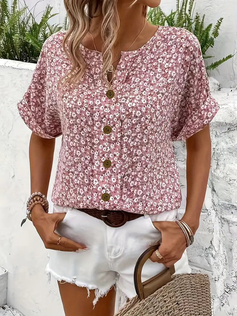 Pink floral print blouse with rounded V-neck, gold button placket, and relaxed fit