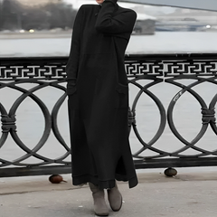 Black hooded winter maxi dress with long sleeves, front pockets, and side slit