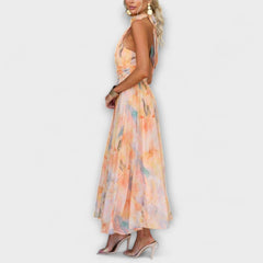 Side view halter midi dress with watercolor orange and blue floral print, flowing skirt