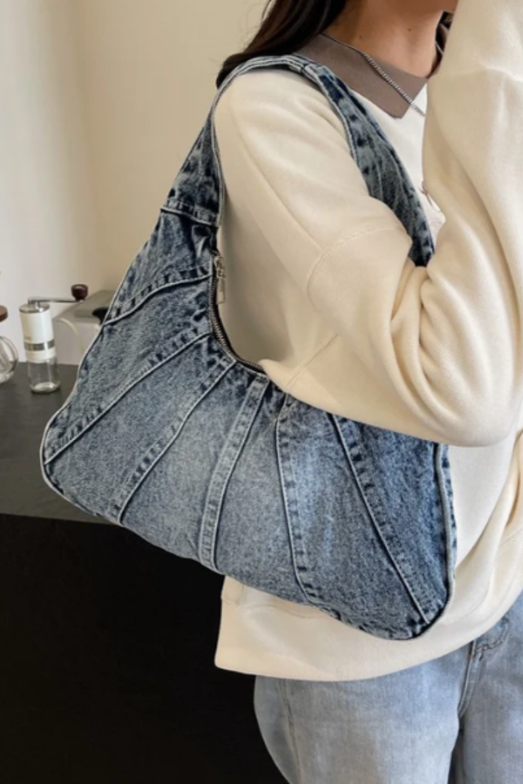 Blue denim shoulder bag with wide straps and stitched panel pattern