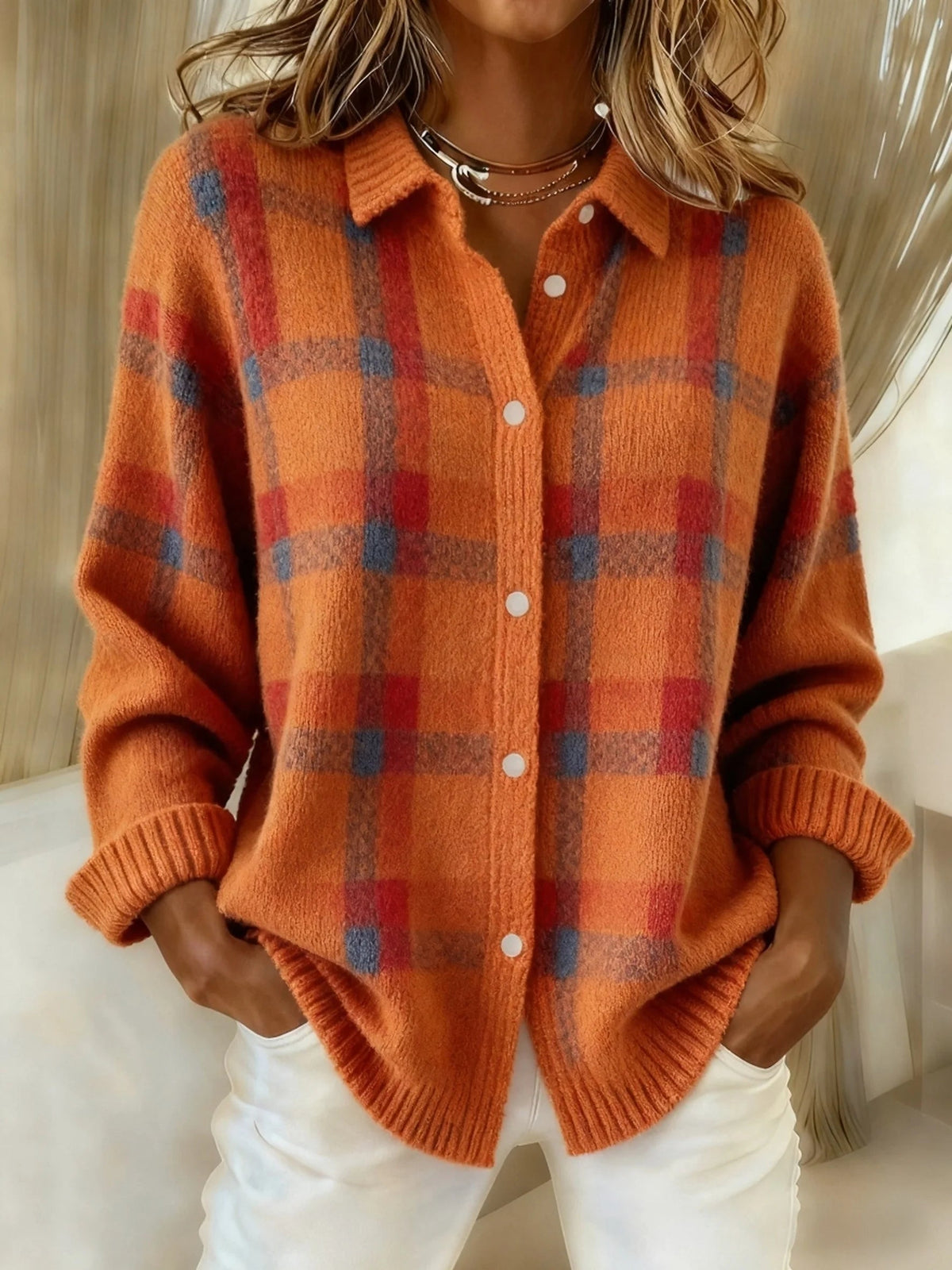 Orange plaid knit vest with V-neck, button front, long sleeves, ribbed cuffs.