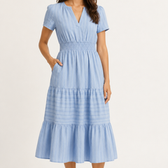 Solene dress in light blue seersucker, V-neck short sleeves, tiered midi skirt.