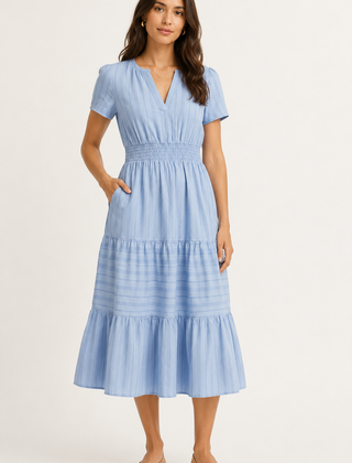 Solene dress in light blue seersucker, V-neck short sleeves, tiered midi skirt.