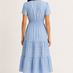 Solene dress in light blue seersucker, back view with smocked waist and tiered skirt.