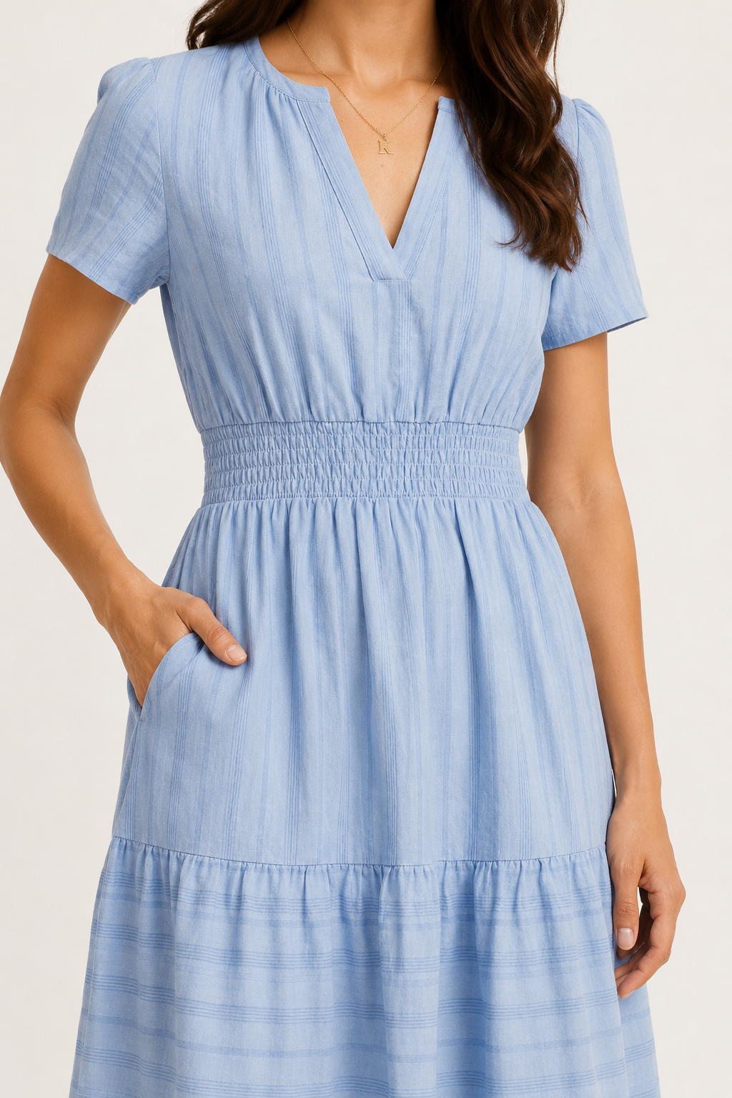 Solene dress in light blue seersucker, V-neck and gathered smocked waist, tiered skirt.
