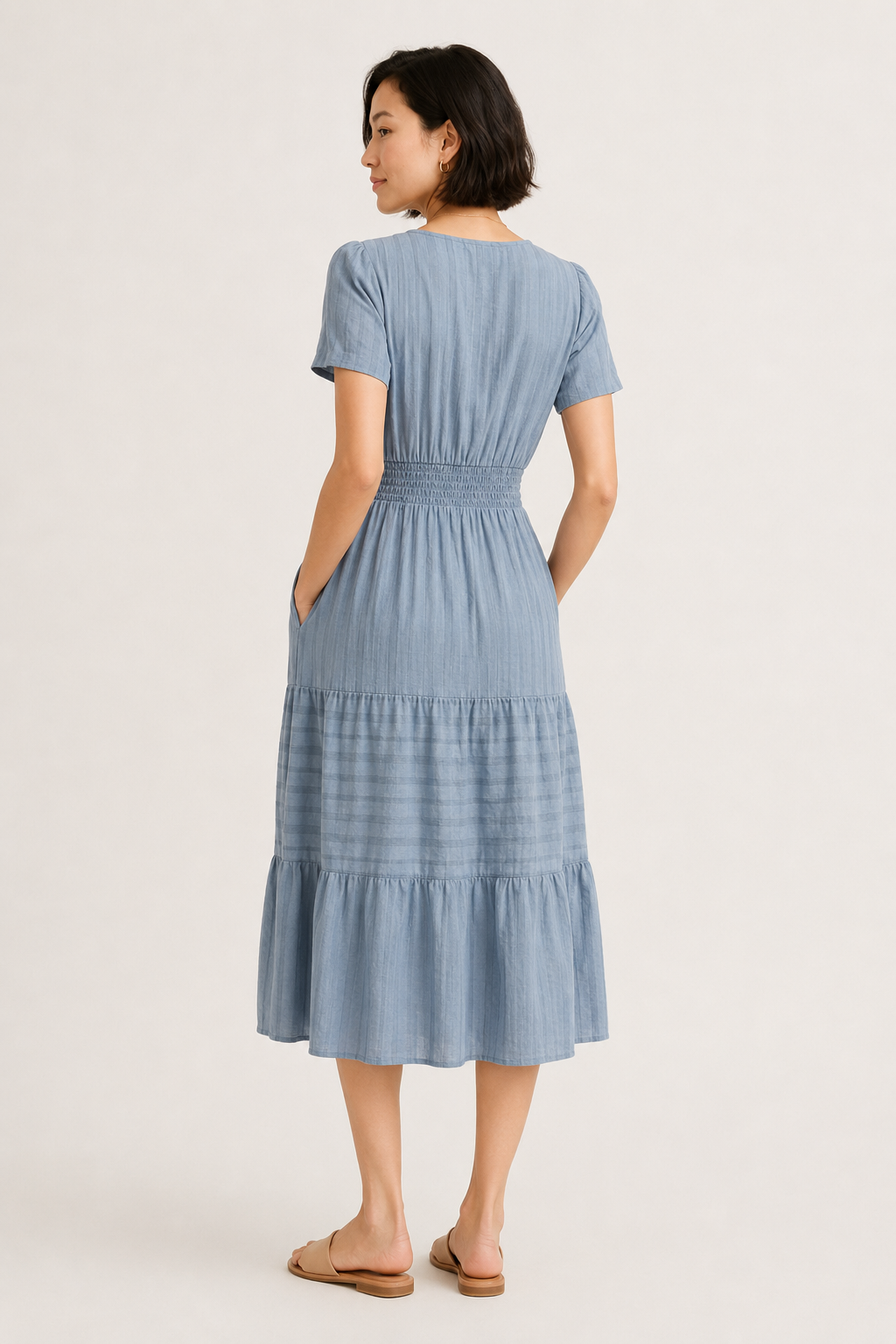 Light blue tiered V-neck midi dress back view with gathered waist and short sleeves