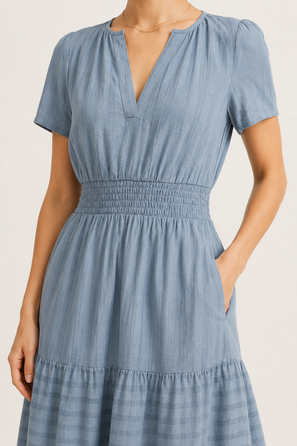 Light blue V-neck midi dress close-up: gathered waist and tiered hem layers