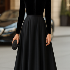 Black velvet midi dress with high neck, long sleeves, fitted bodice and flared skirt