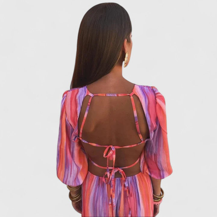 Back view of multicolor striped long dress with open back and bow detail