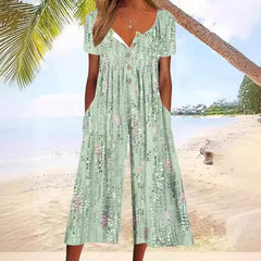 Green floral jumpsuit with V-neck button front, short sleeves, and tiered wide legs