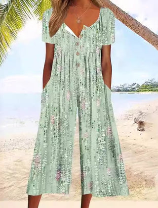 Green floral jumpsuit with V-neck button front, short sleeves, and tiered wide legs