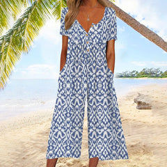 Blue patterned jumpsuit with V-neck button front, short sleeves, and wide legs