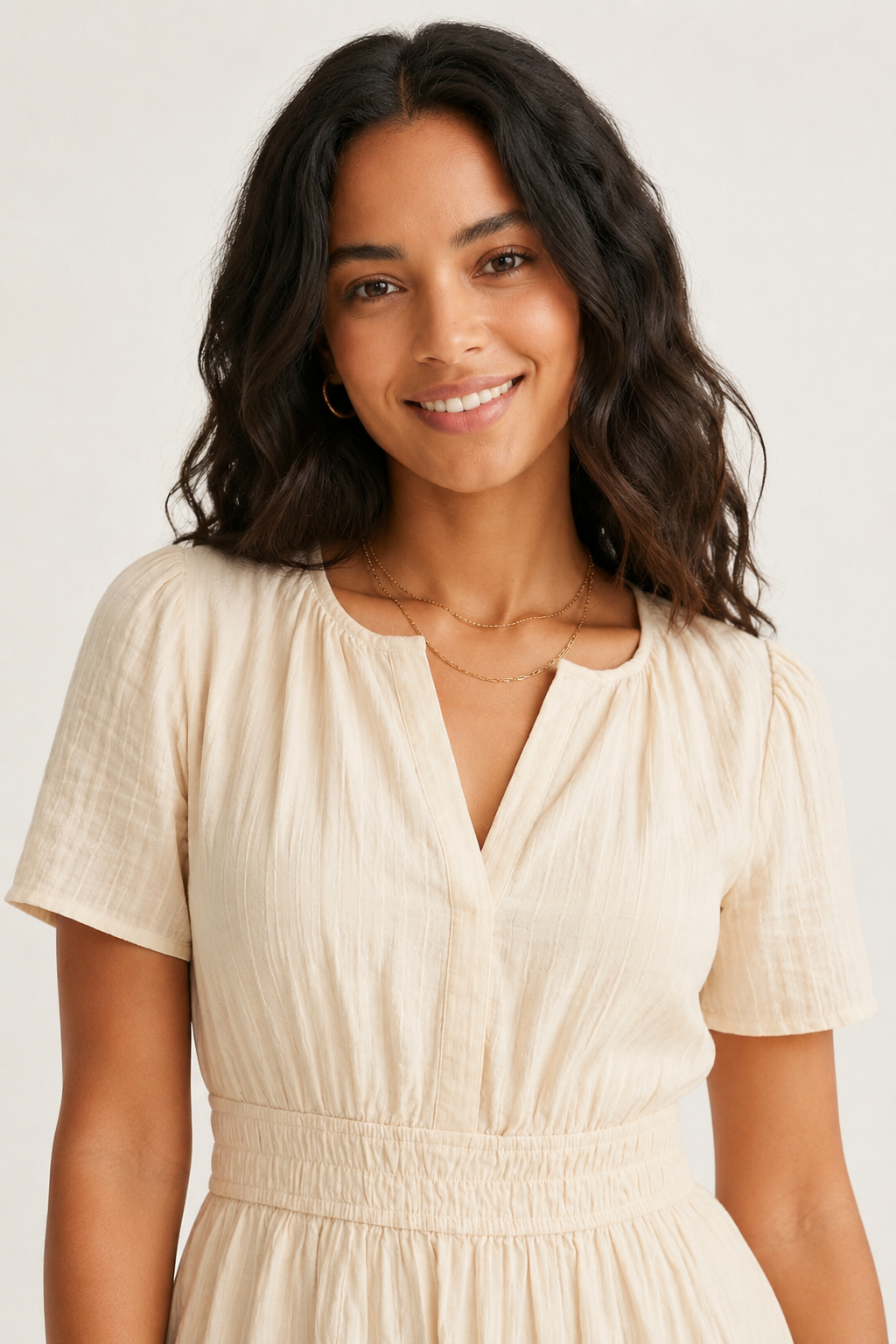 Solene dress portrait close-up, light cream V-neck, short sleeves, gathered waist seam