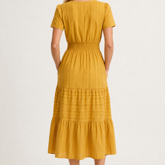Mustard yellow tiered midi dress with short sleeves and smocked waist, back view