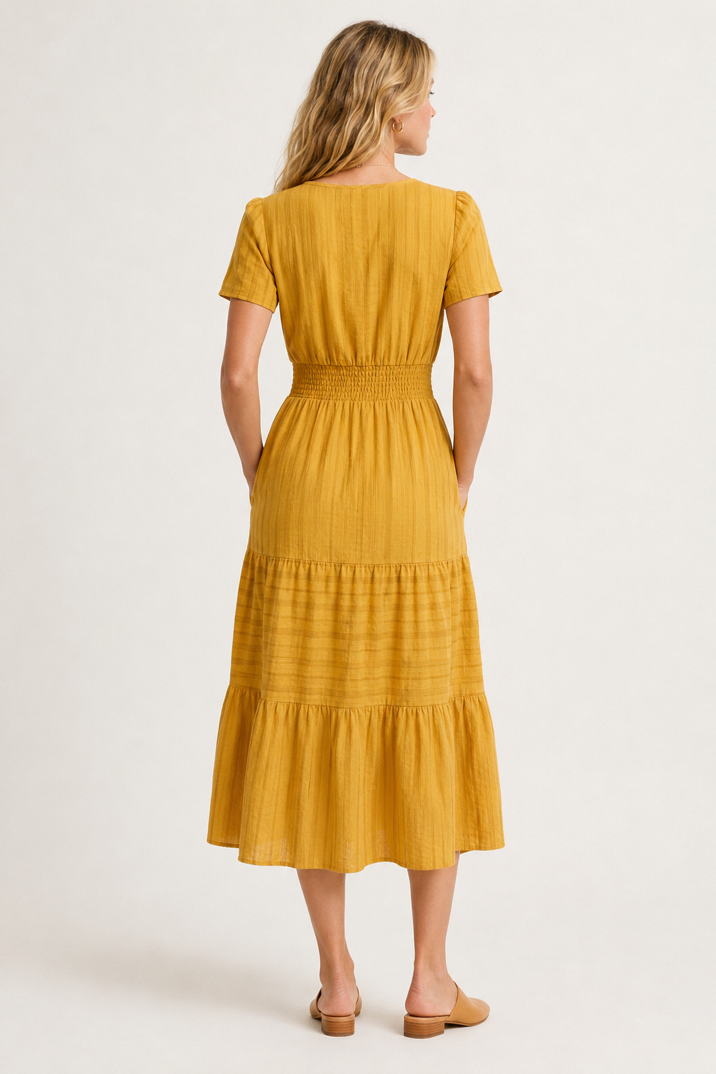 Mustard yellow tiered midi dress with short sleeves and smocked waist, back view