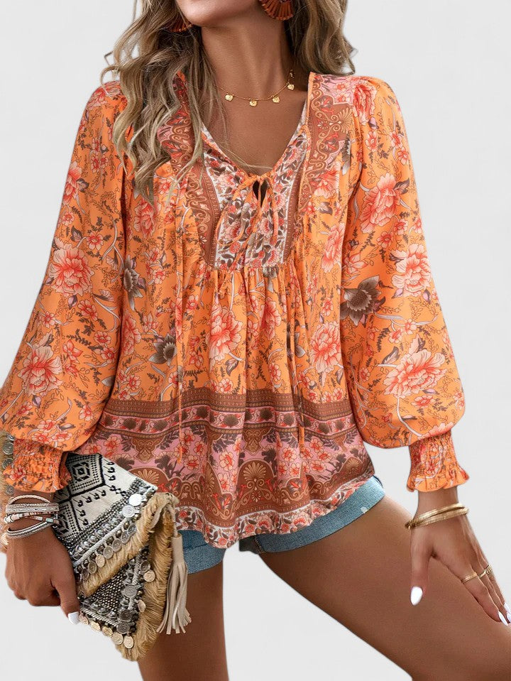 Orange printed peasant blouse with round neckline, elastic cuffs, long balloon sleeves