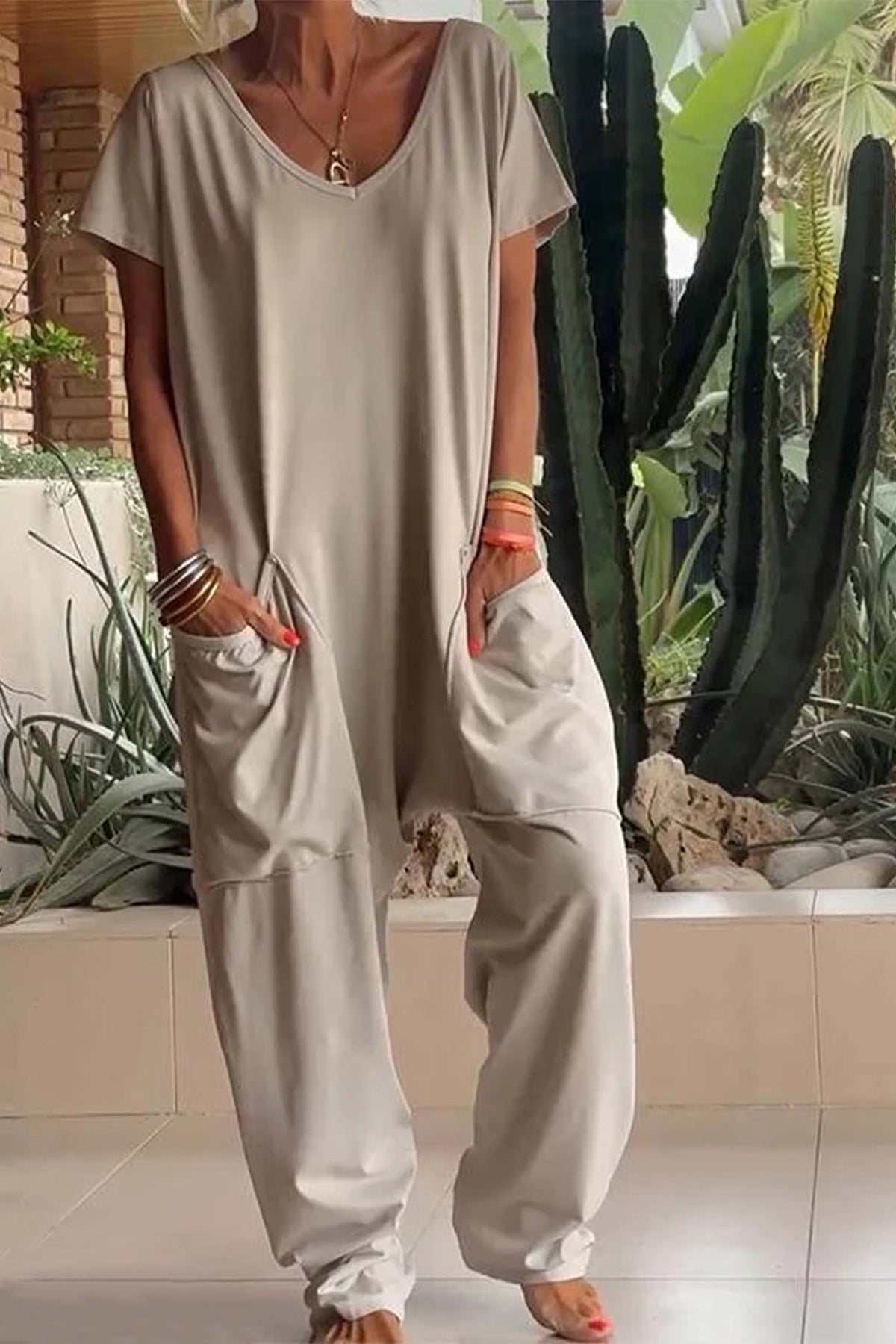 Stone beige V-neck short-sleeve jumpsuit with patch pockets and relaxed fit