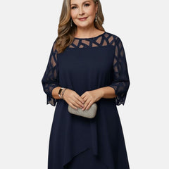 Deep blue dress with sheer patterned sleeves, geometric yoke, and layered asymmetric hem