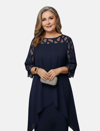 Deep blue dress with sheer patterned sleeves, geometric yoke, and layered asymmetric hem