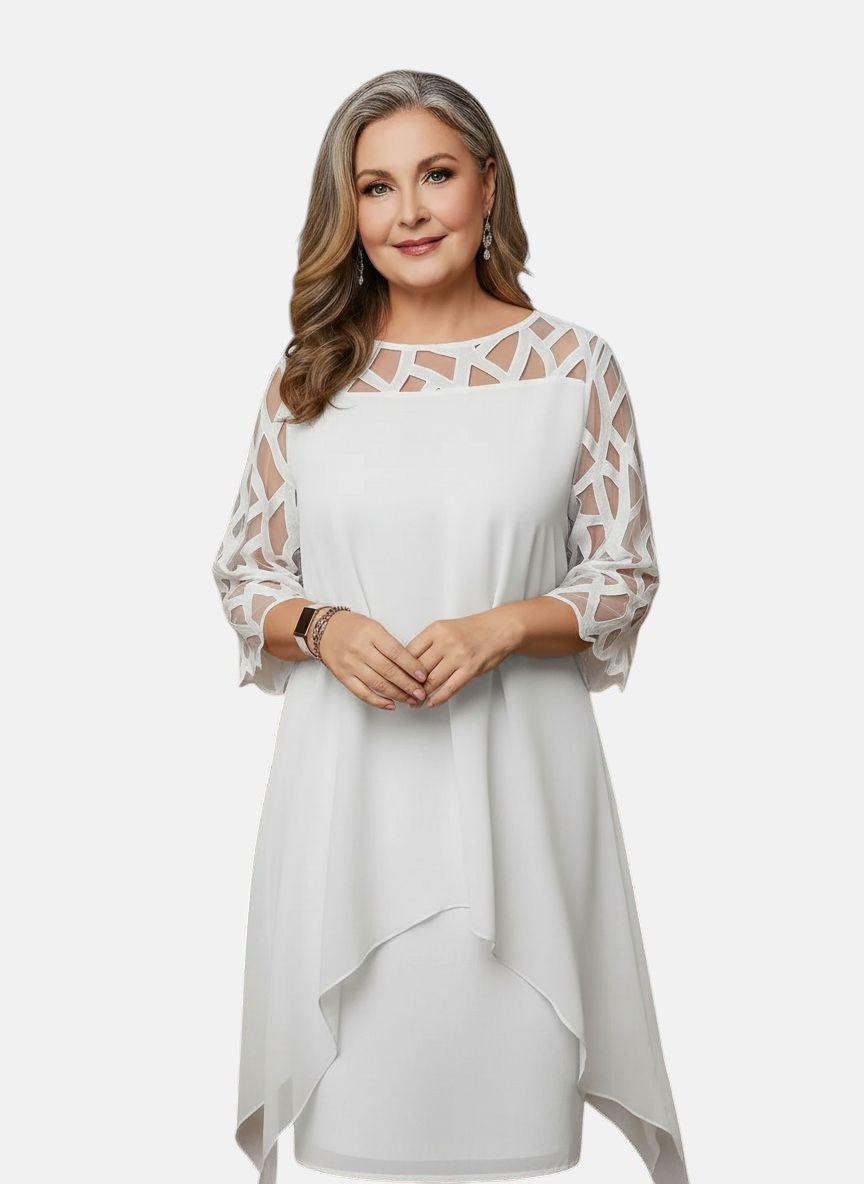 White dress with sheer patterned sleeves, geometric cutout yoke, and draped asymmetric hem
