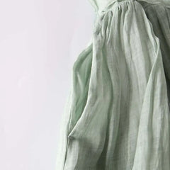 Women’s green gathered waist dress with pleated skirt and flowing sleeves