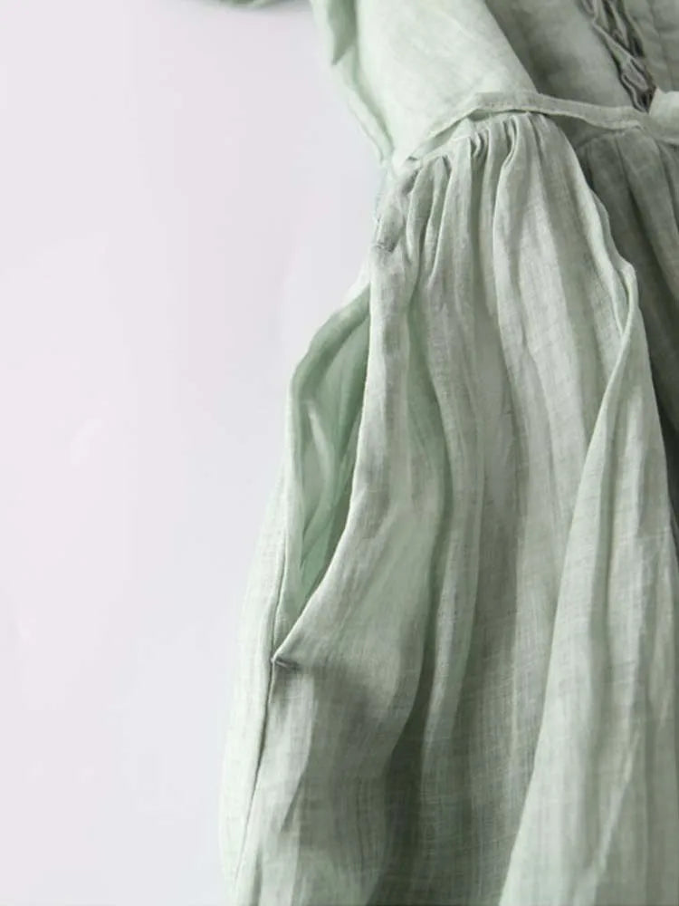 Women’s green gathered waist dress with pleated skirt and flowing sleeves