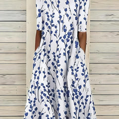 Coastal Bloom dress with white background and blue leaf-stem print, short sleeves