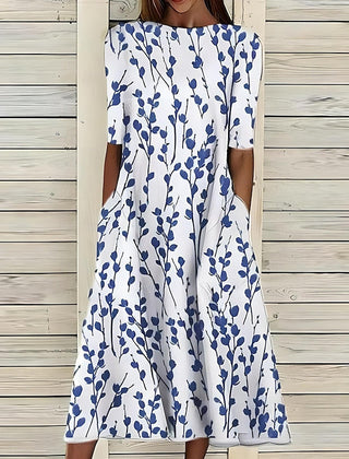 Coastal Bloom dress with white background and blue leaf-stem print, short sleeves