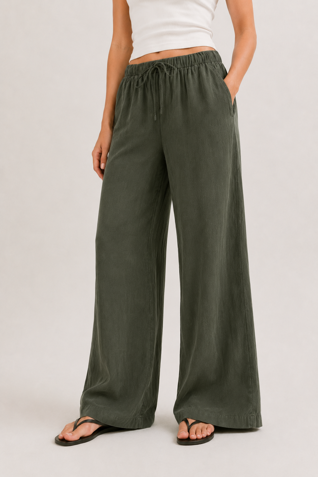 Dark green wide-leg pants with elastic drawstring waist and relaxed legs.
