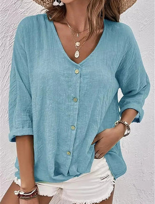 Medium blue V-neck button-front top with loose three-quarter sleeves.