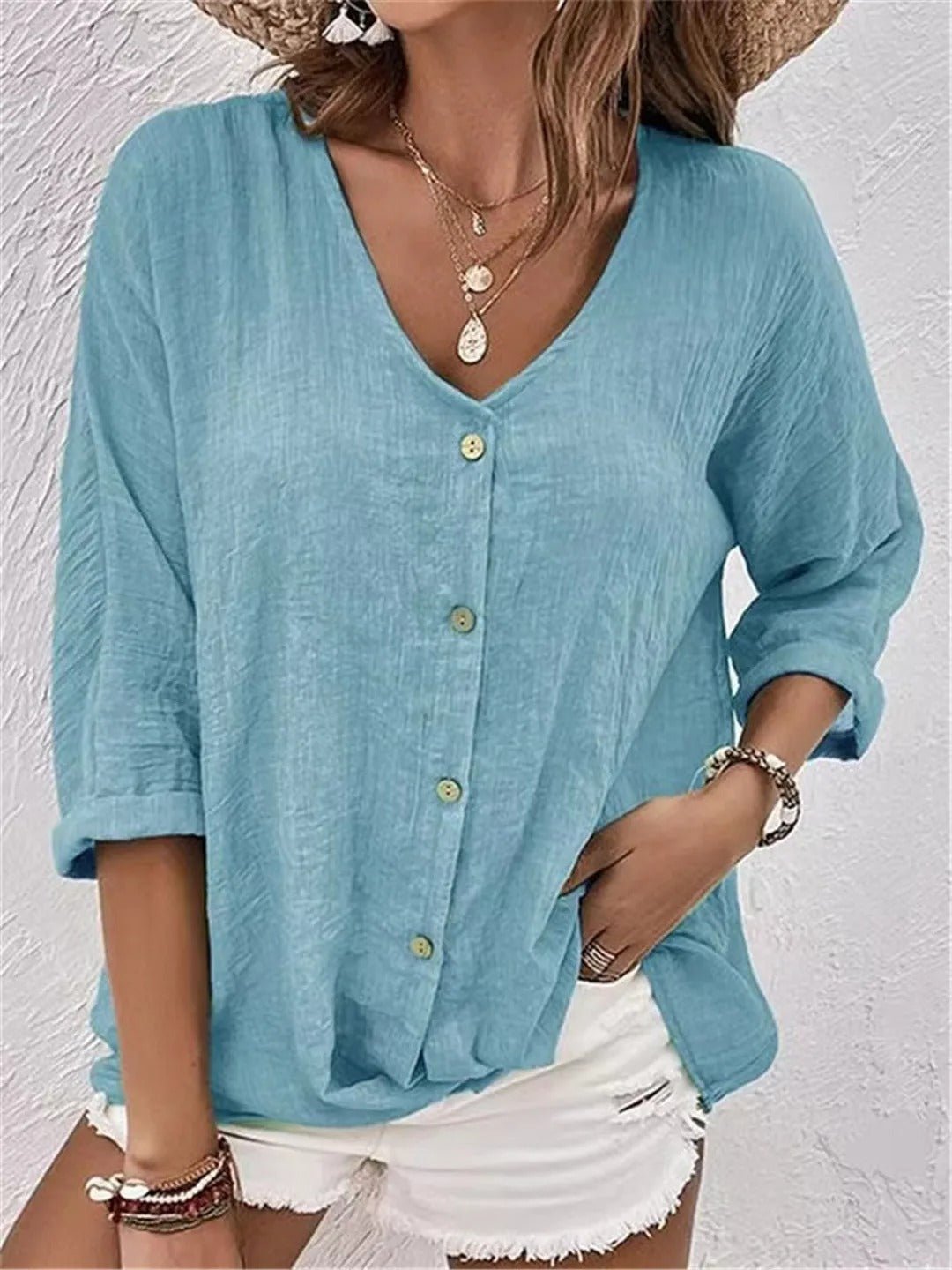 Medium blue V-neck button-front top with loose three-quarter sleeves.