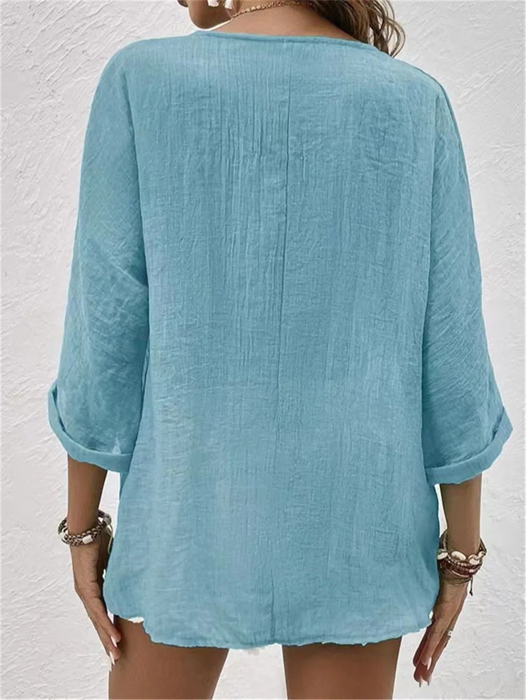 Light blue relaxed top with three-quarter sleeves and a plain back.