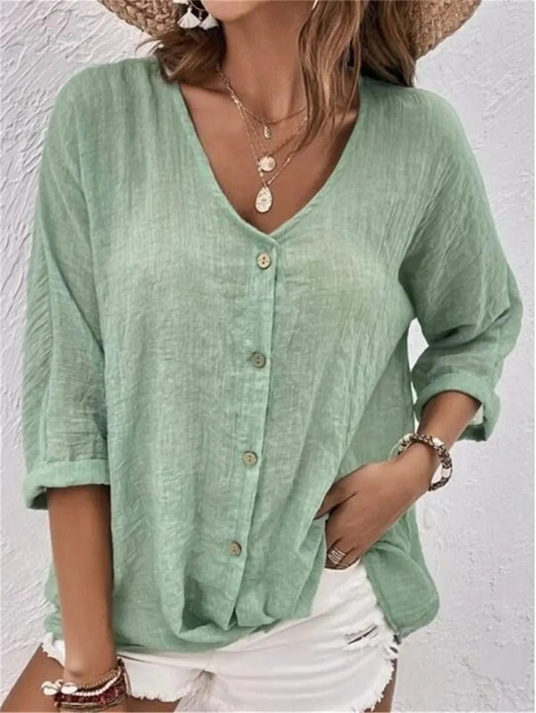 Mint green V-neck button-front top with loose three-quarter sleeves.
