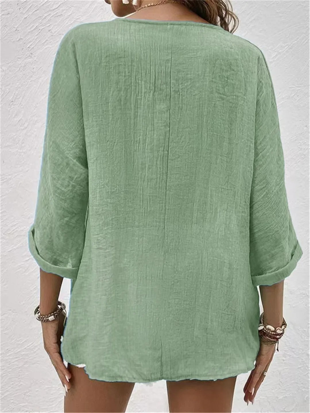 Mint green relaxed top with three-quarter sleeves and a plain back.