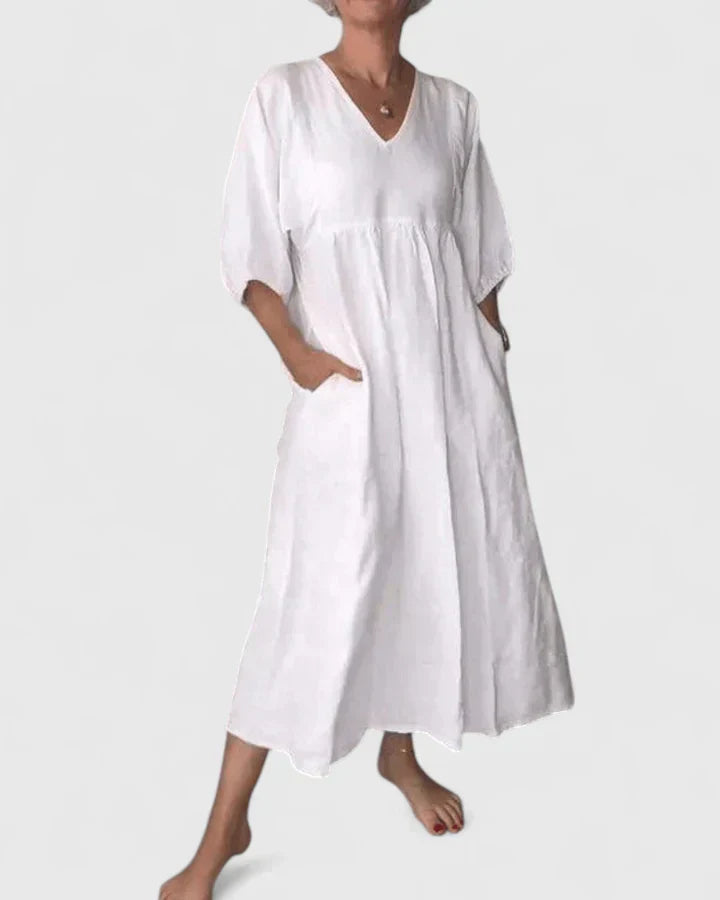White maxi dress with V-neck, loose fit, and draped short sleeves