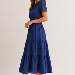 Royal blue tiered V-neck midi dress in side view with short sleeves and buttoned placket