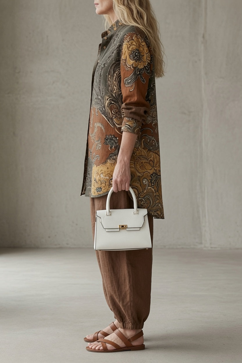 Paisley button-up shirt and loose brown pants with white handbag
