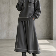 Women's charcoal gray knit set close-up: patch-pocket sweatshirt and flared midi skirt