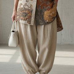 Patterned button-up shirt with cream drawstring pants and tan slide sandals