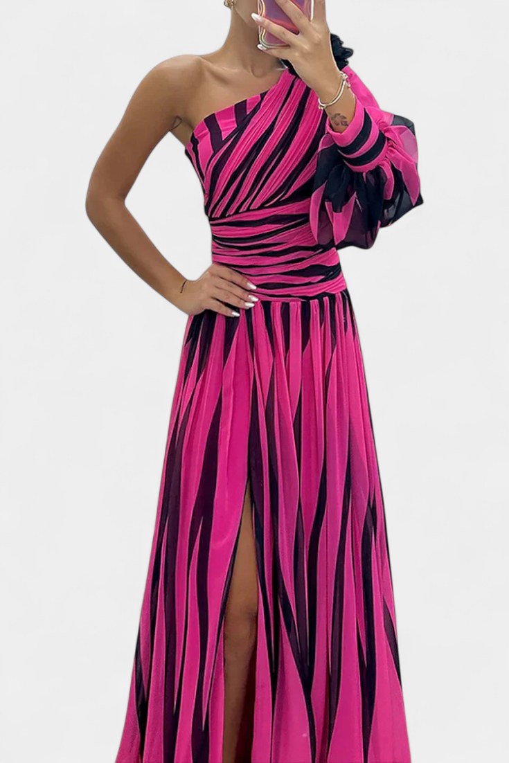 Striped one-shoulder maxi dress in fuchsia and dark tones, fitted bodice, side slit.