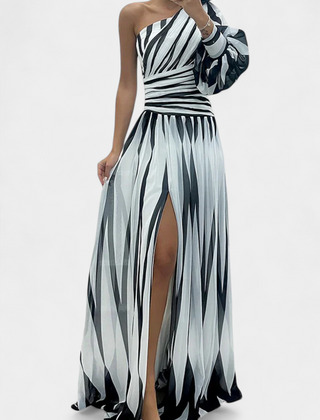 One-shoulder striped maxi dress in light and dark tones, draped bodice, side slit.