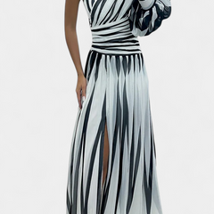 One-shoulder striped maxi dress in light and dark tones, ruched bodice, side slit.